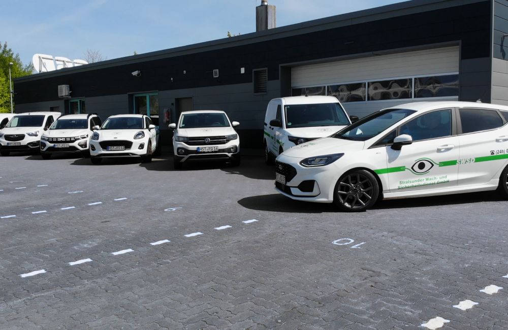 Firmenfahrzeuge vor Firmengebäude